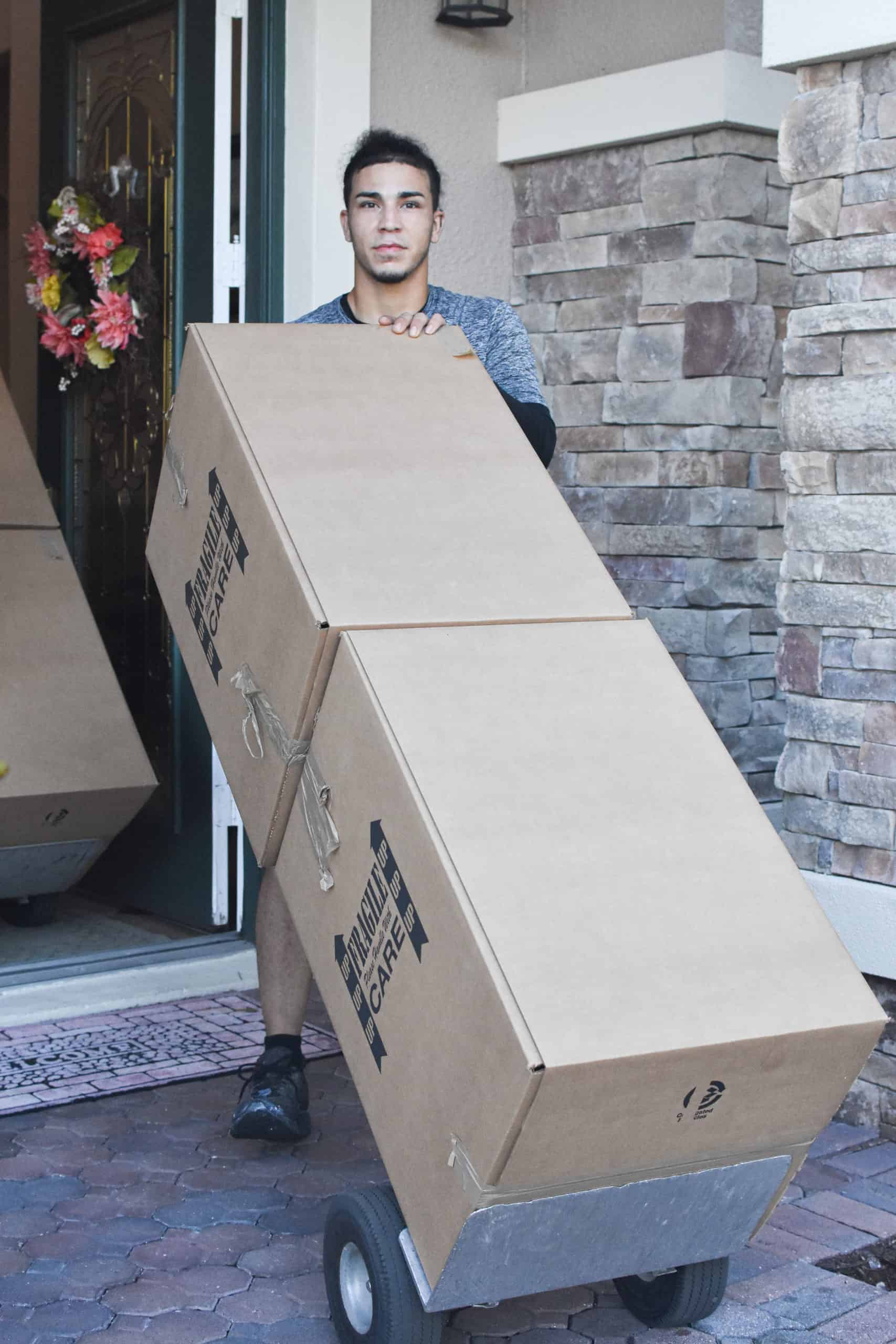 This is an image of a Teleport Moving employee with boxes on a dolley.